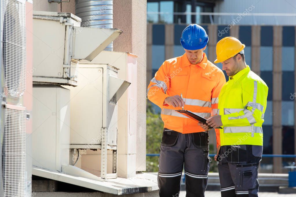 Tecnico che verifica un impianto elettrico con checklist alla mano