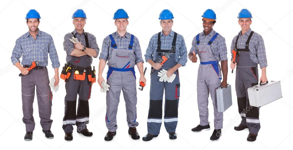 Tecnici impiantisti al lavoro su un quadro e tubazioni